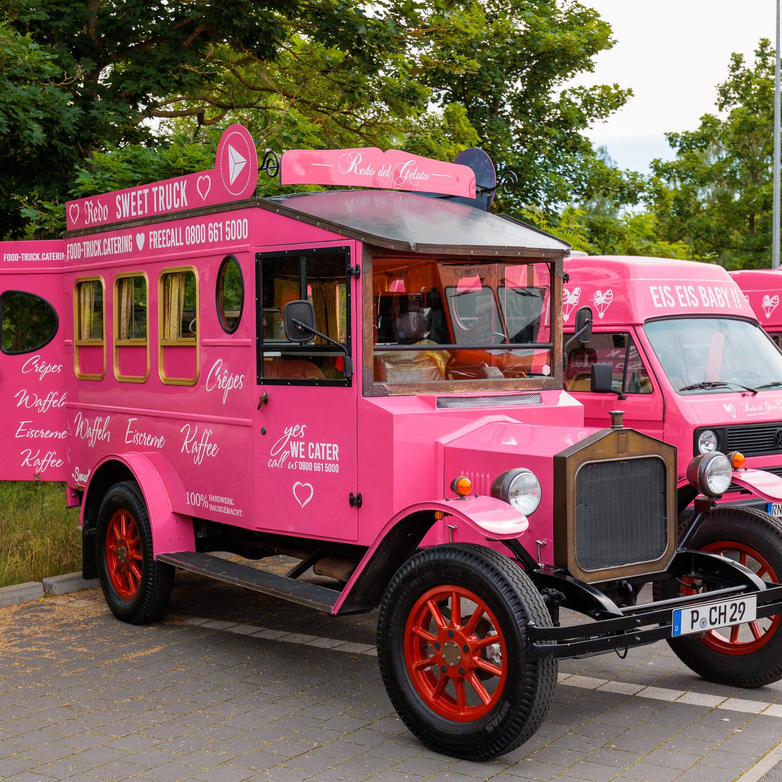 Der pinke Eiswagen im Stil eines Oldtimers mit der Aufschrift Eis Eis Baby, dahinter zwei weitere pinke Fahrzeuge der Flotte